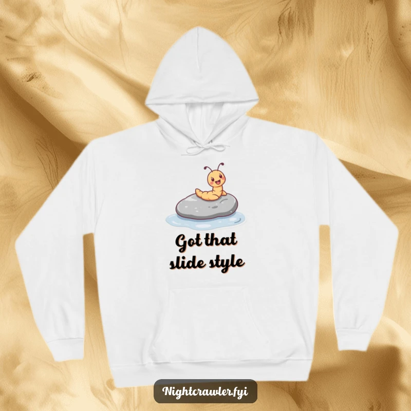 Funny hoodie illustrating a tiny worm character joyfully sliding down a smooth, wet pebble, offering warmth and whimsical cheer.
